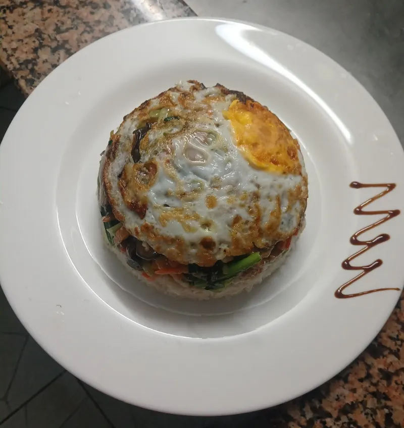Une assiette du restaurant : un dôme de riz, des légumes sautés et un œuf au plat